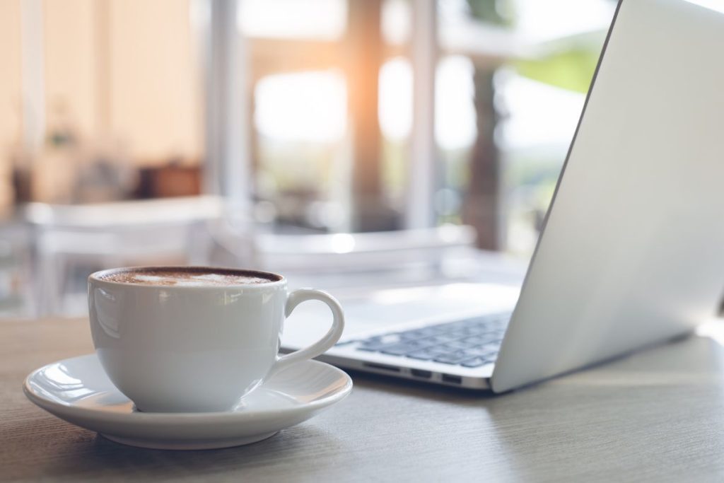 Laptop and coffee on desk for a digital nomad