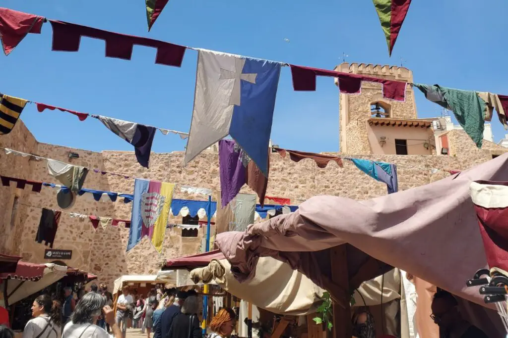 santa pola castle medieval market Santa Pola castle with colours flags, stalls, and crowds for the Medieval Market