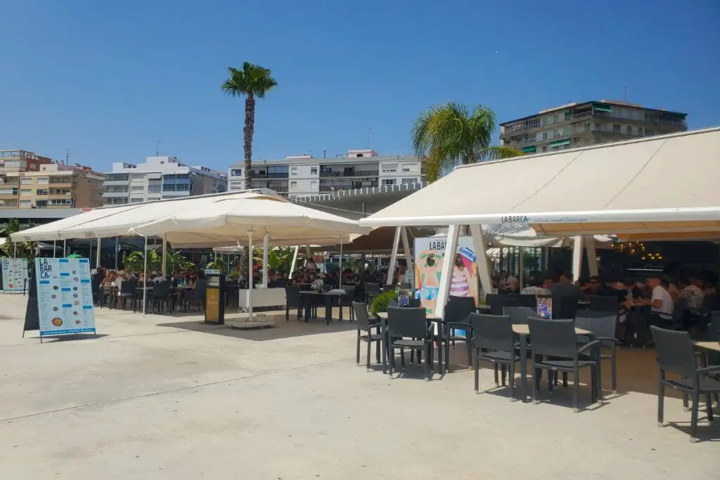 santa pola la barca La Barca restraunt in Santa Pola with tables and chairs on the promenade underneath white awnings