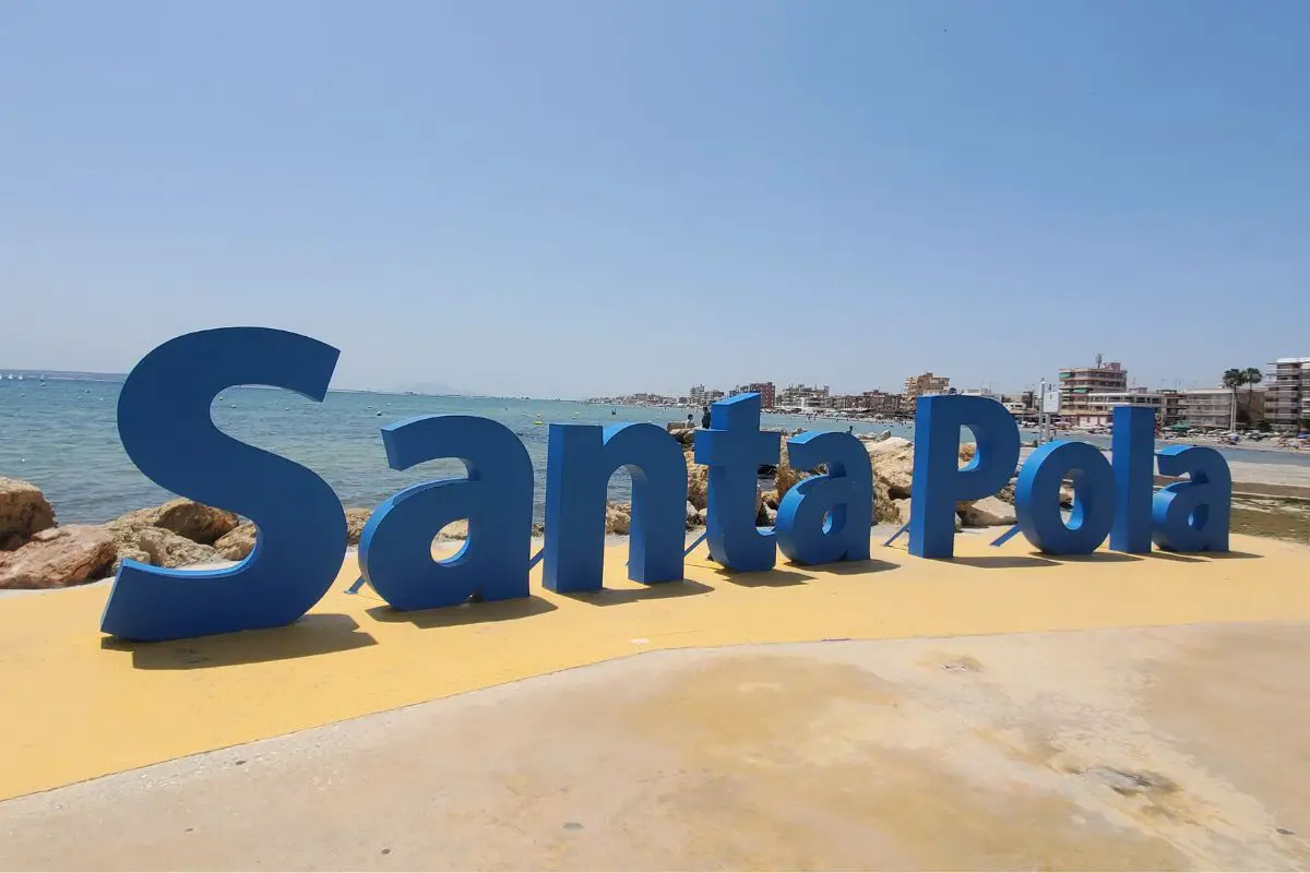 Blue sign spelling Santa Pola in front of the sea